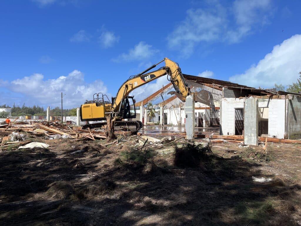 Excavator tearing down wake island structure