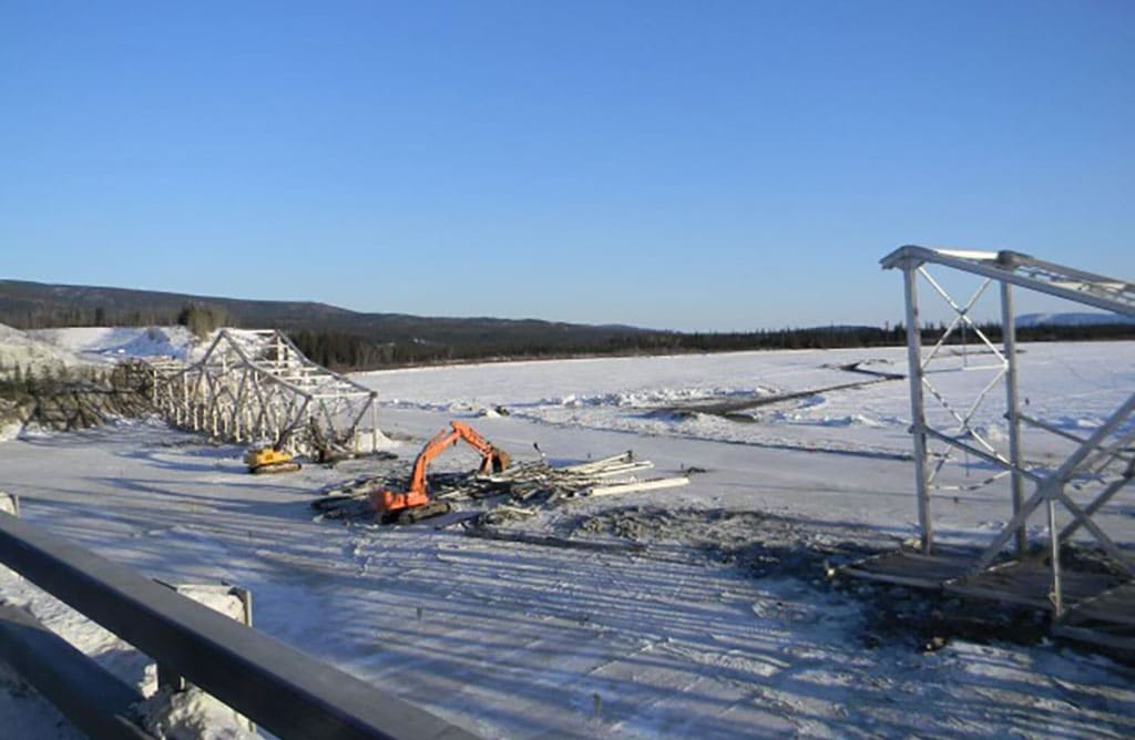 Excavator demolishing Tanana bridge