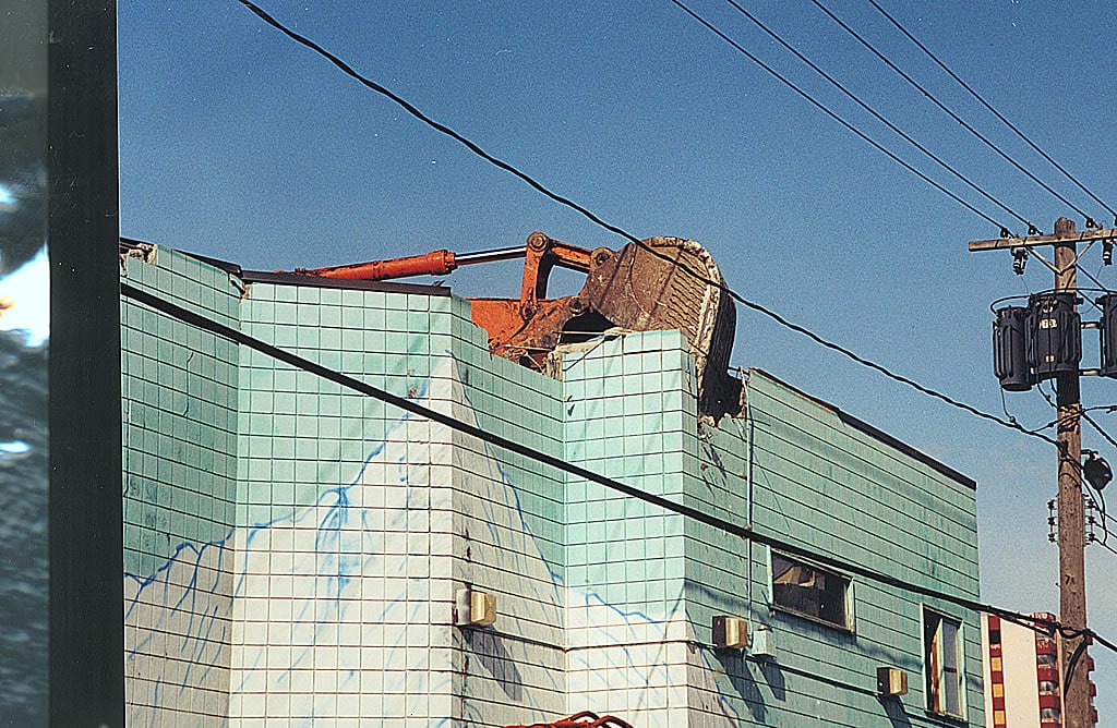 Excavator bucket tearing down building