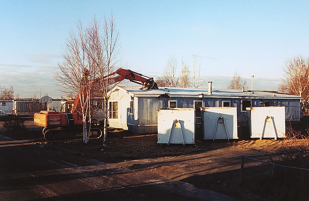 Excavator tearing down house