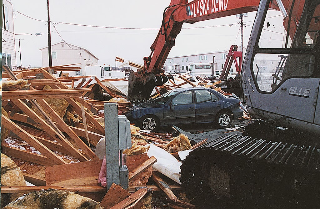 Excavator destroying a car