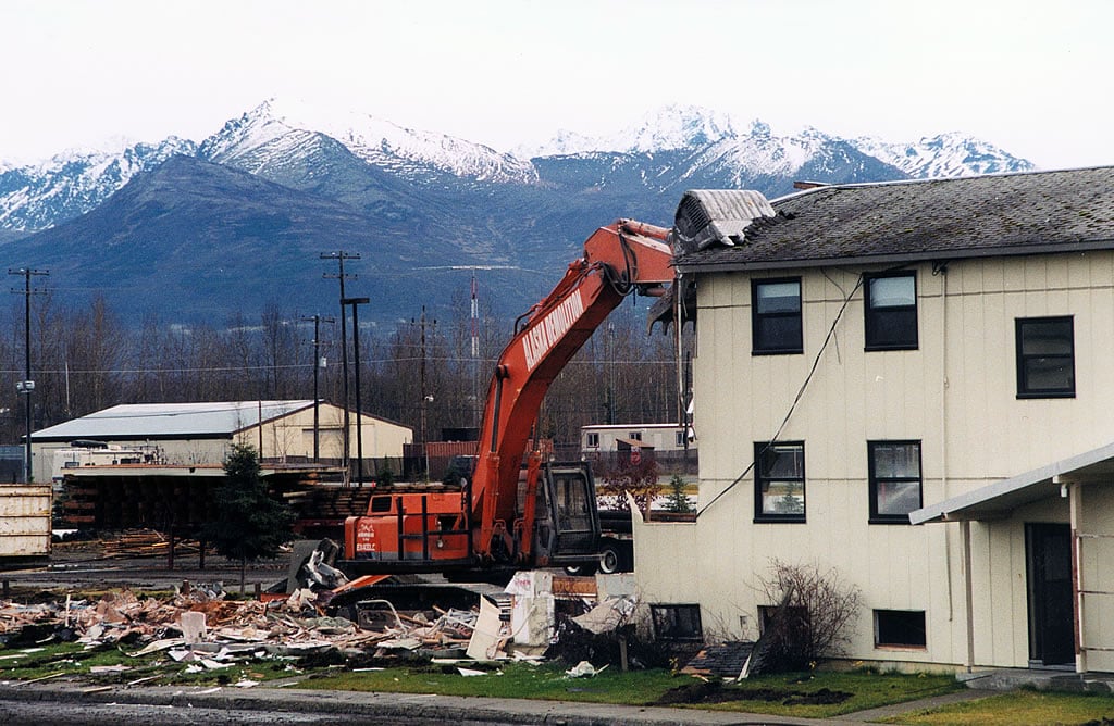 Excavator destroying a house
