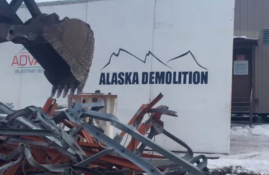 Alaska Demolition logo next to scraps